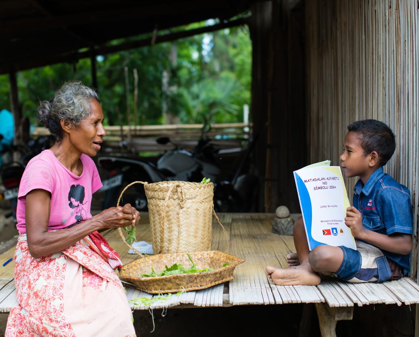 妇女和小男孩一起坐在小屋的边上 