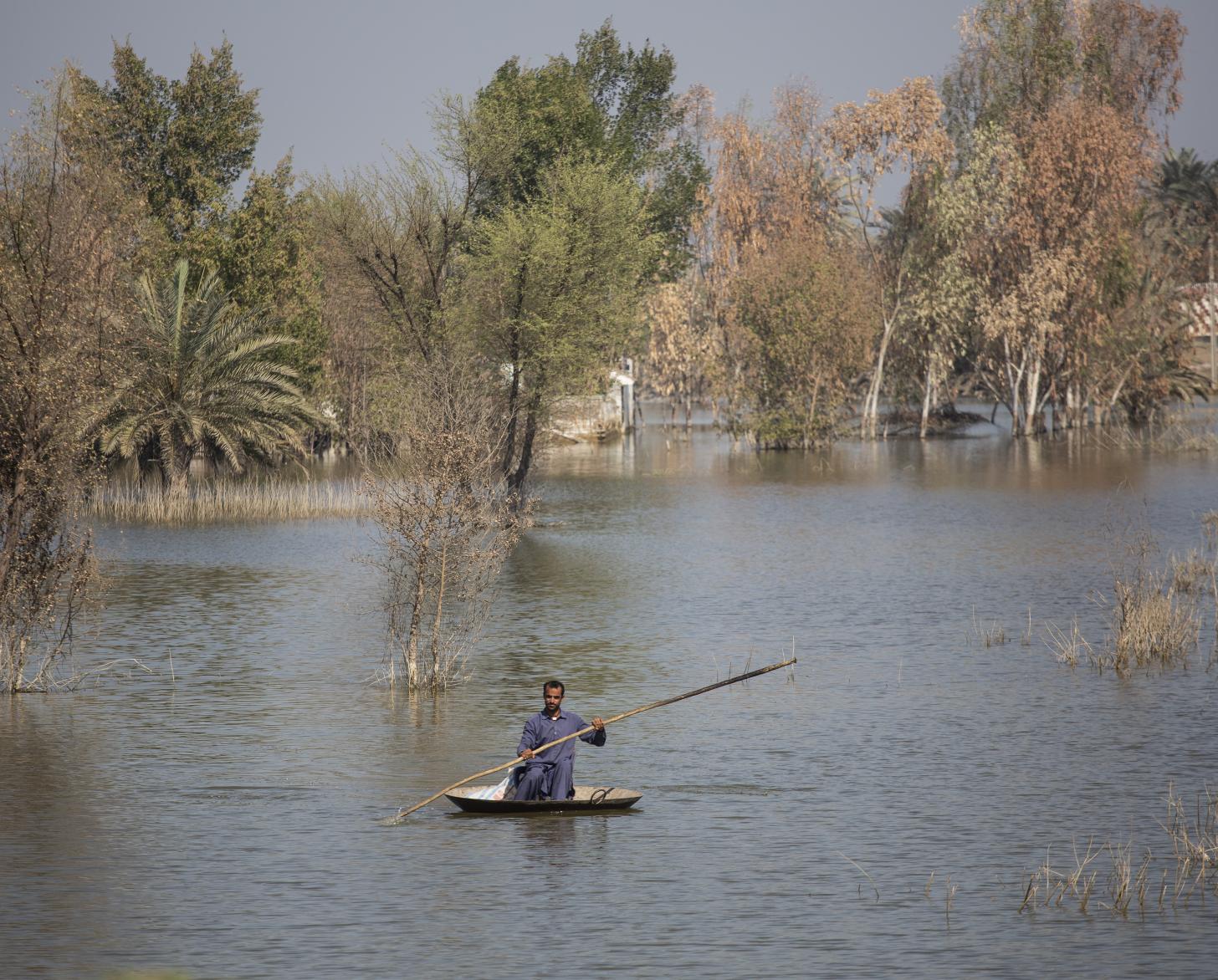 man in small raft floats down a river 