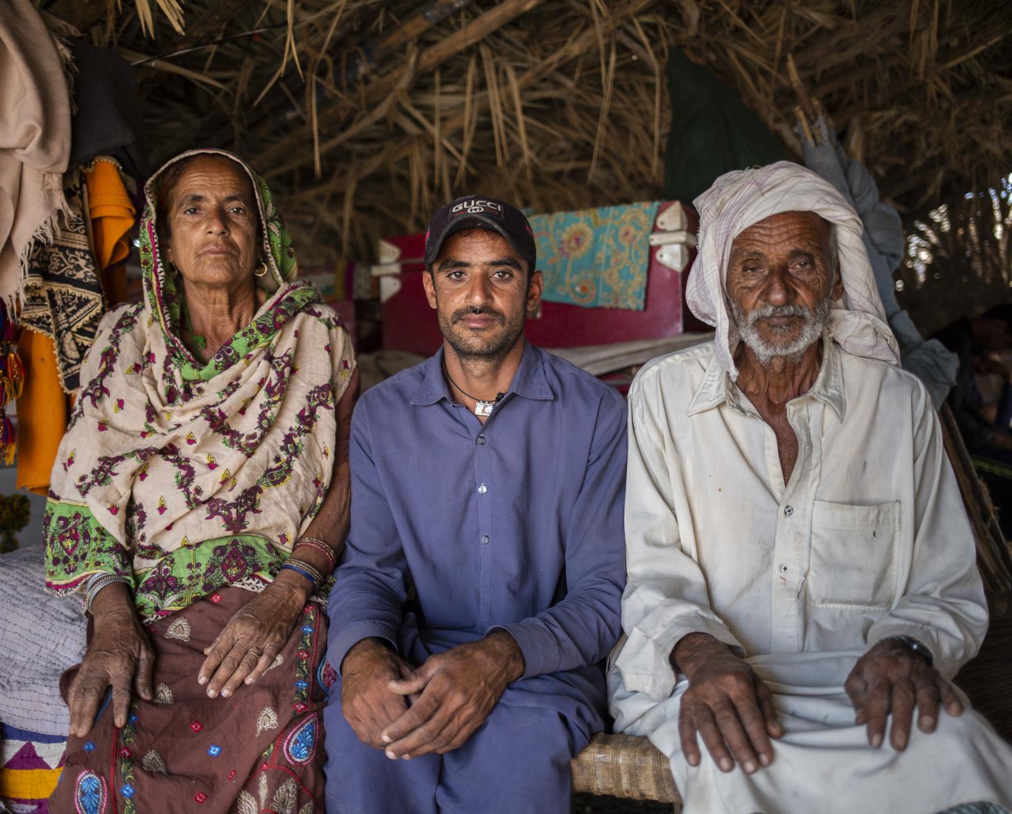 two men and a women sit side by side in a tent looking towards the camera 