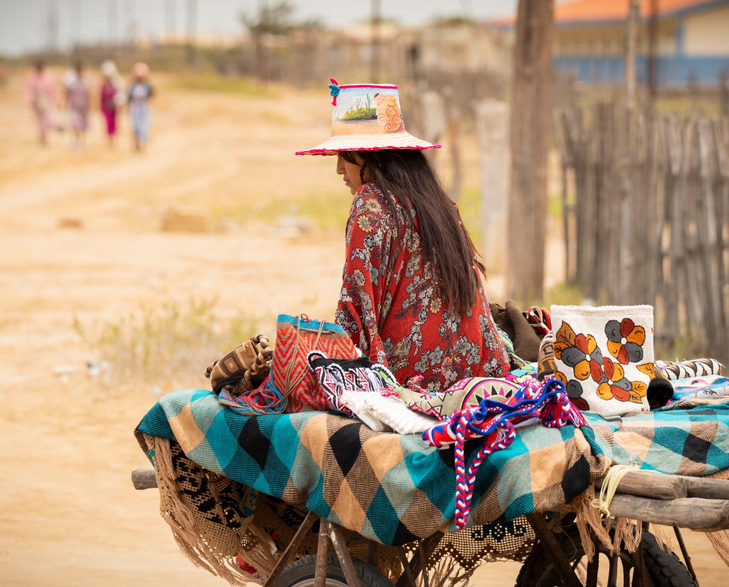 Weavers of Paraguaipoa prepared a set of textiles to be retailed in a fair in Maracaibo. A girl from the community accompanies the products for the fair.