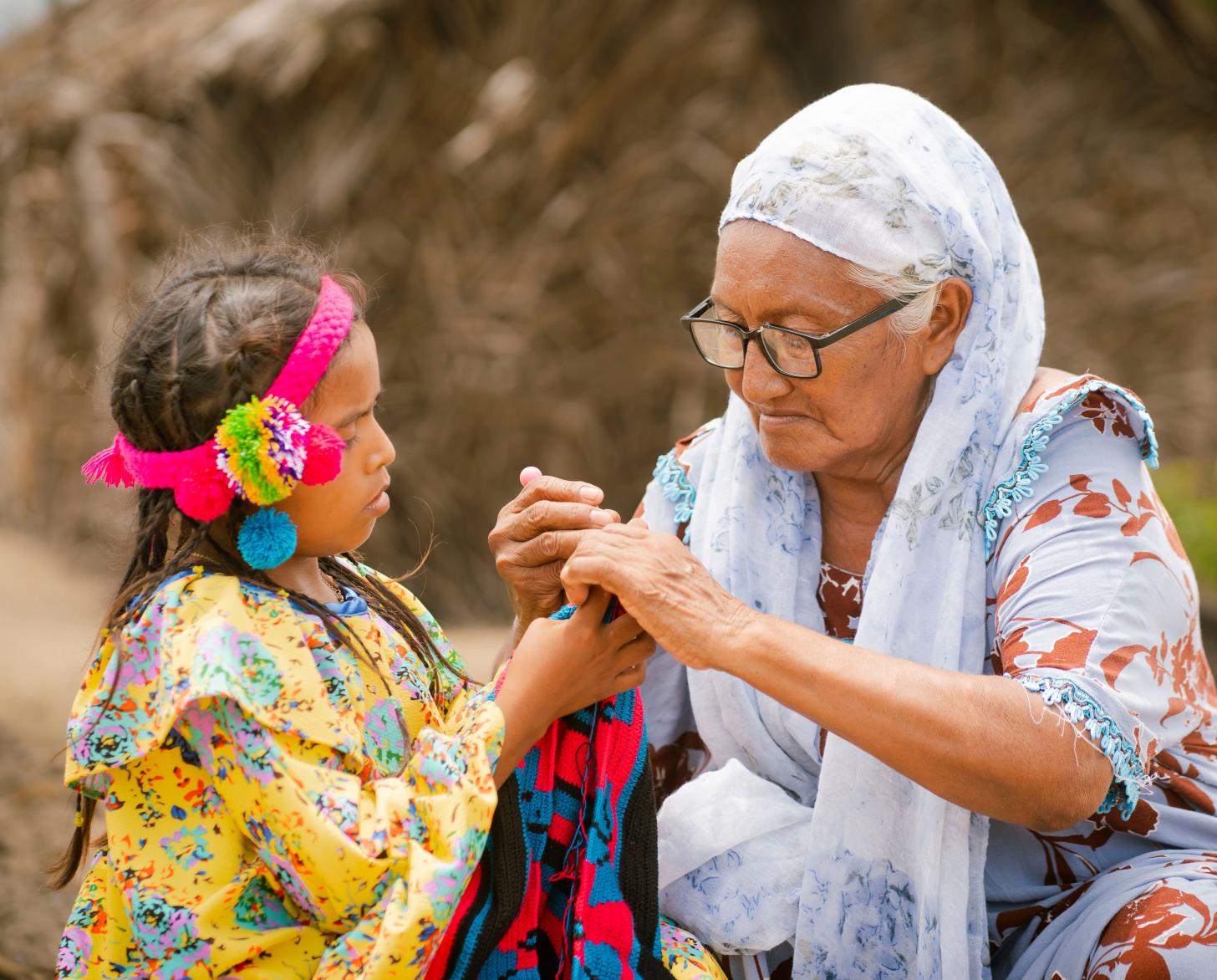 Freyla González (72), senior weawer of Paraguaipoa teaches her granddaughter how to weave in the premises of the yarn cone bank. 