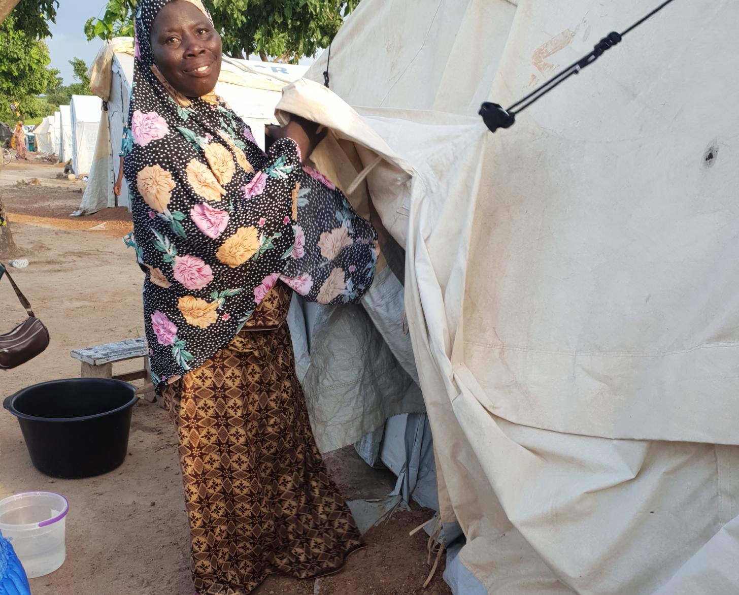 An asylum seeker stands outside her tent at the Tarikom Settlement Centre