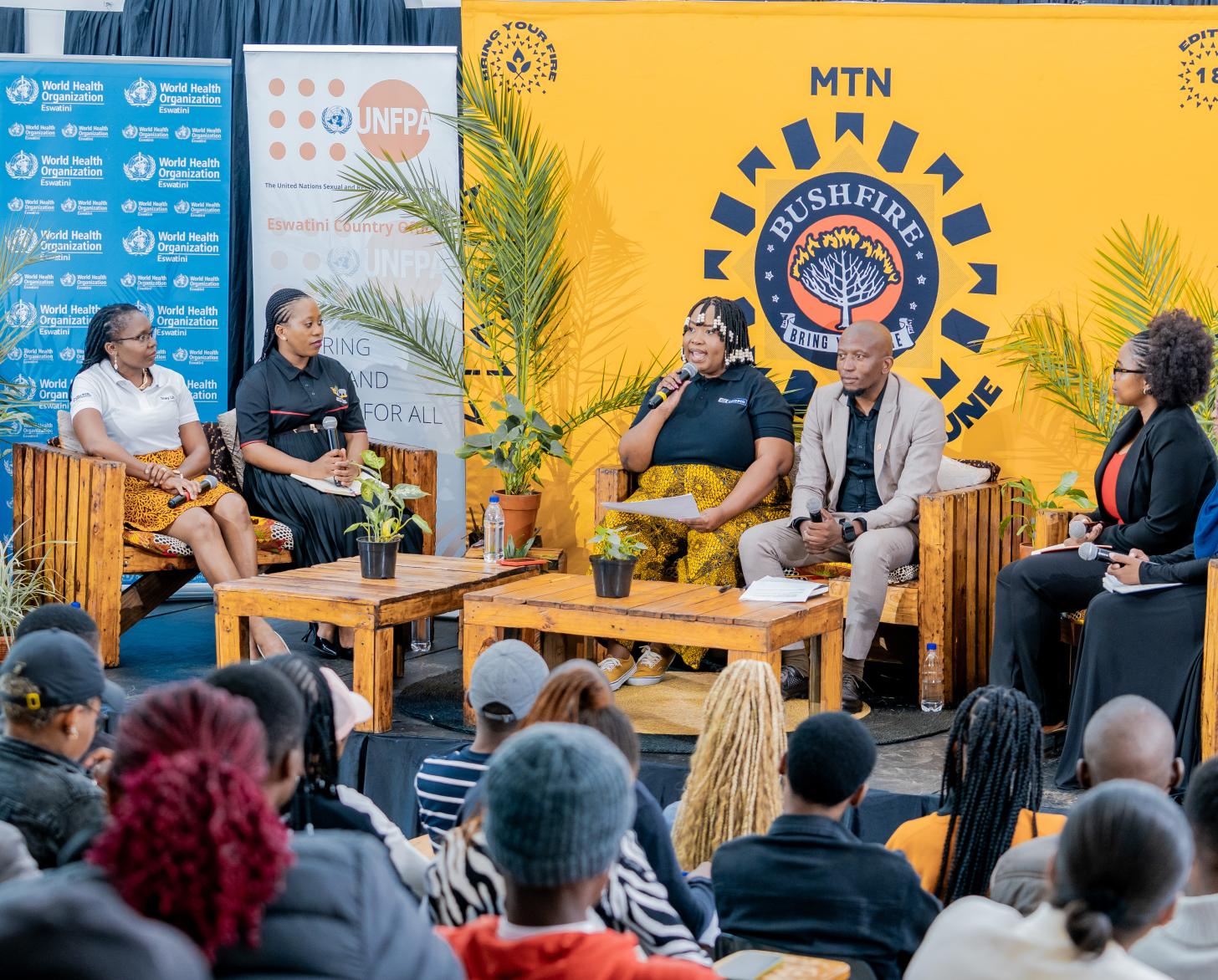 A group of six panelists discuss in front of an audience