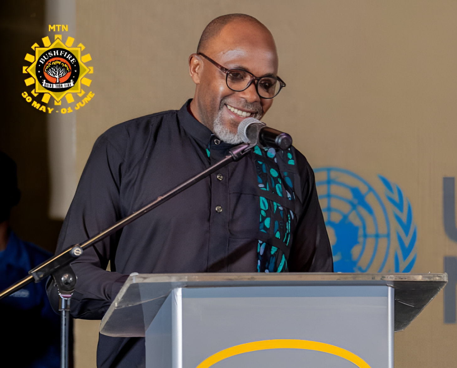 A man speaks into a microphone on a podium