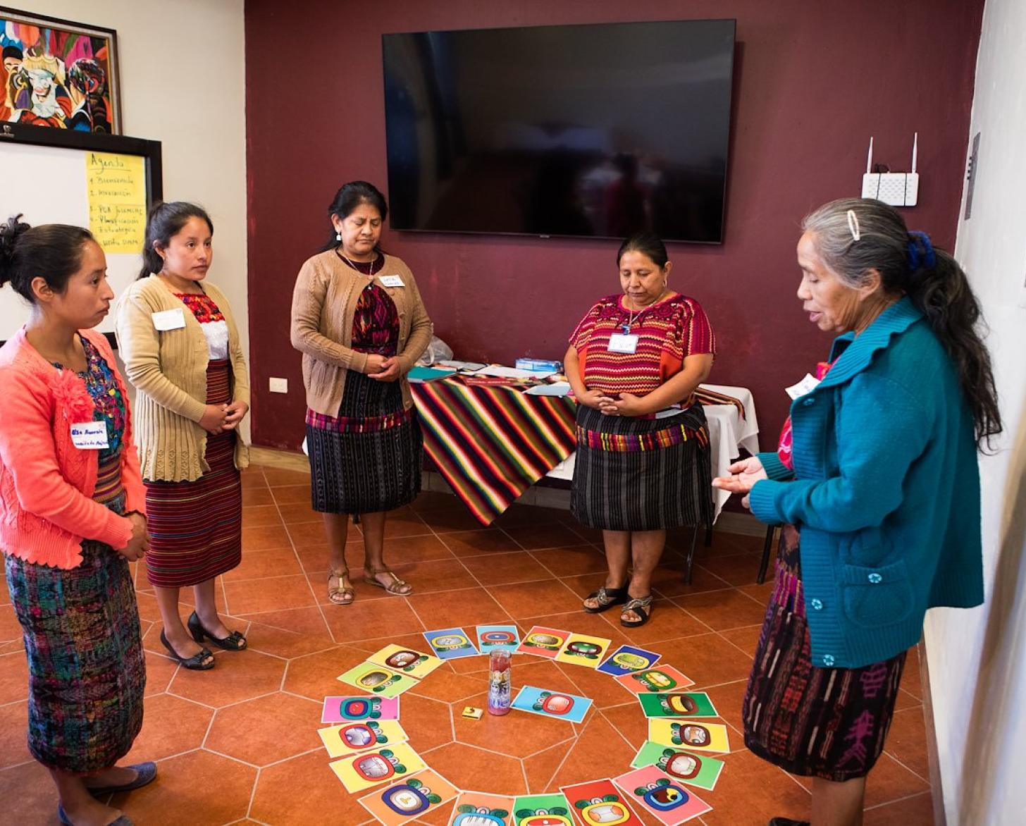 A group of women in a circle engaging in an activity 