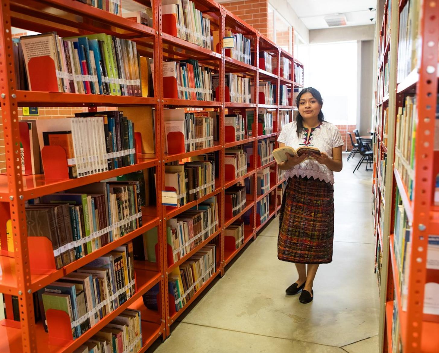 A woman in a library reading a book 