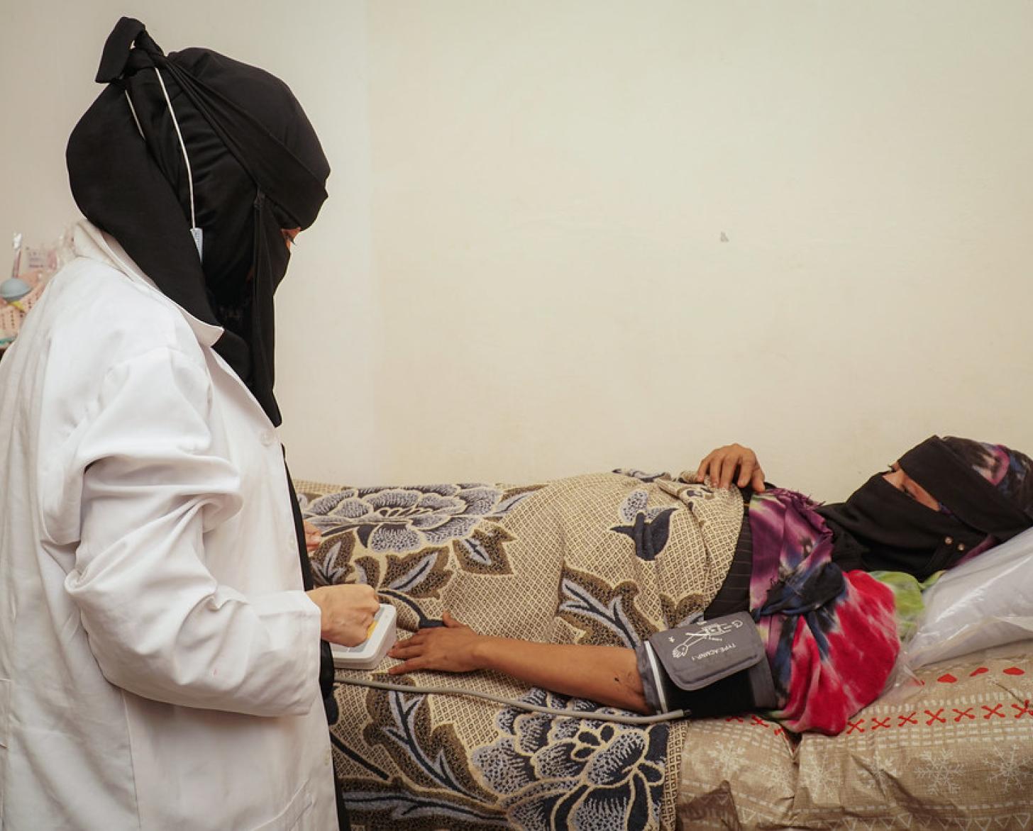 A Yemeni nurse oversees a woman who recently gave birth.