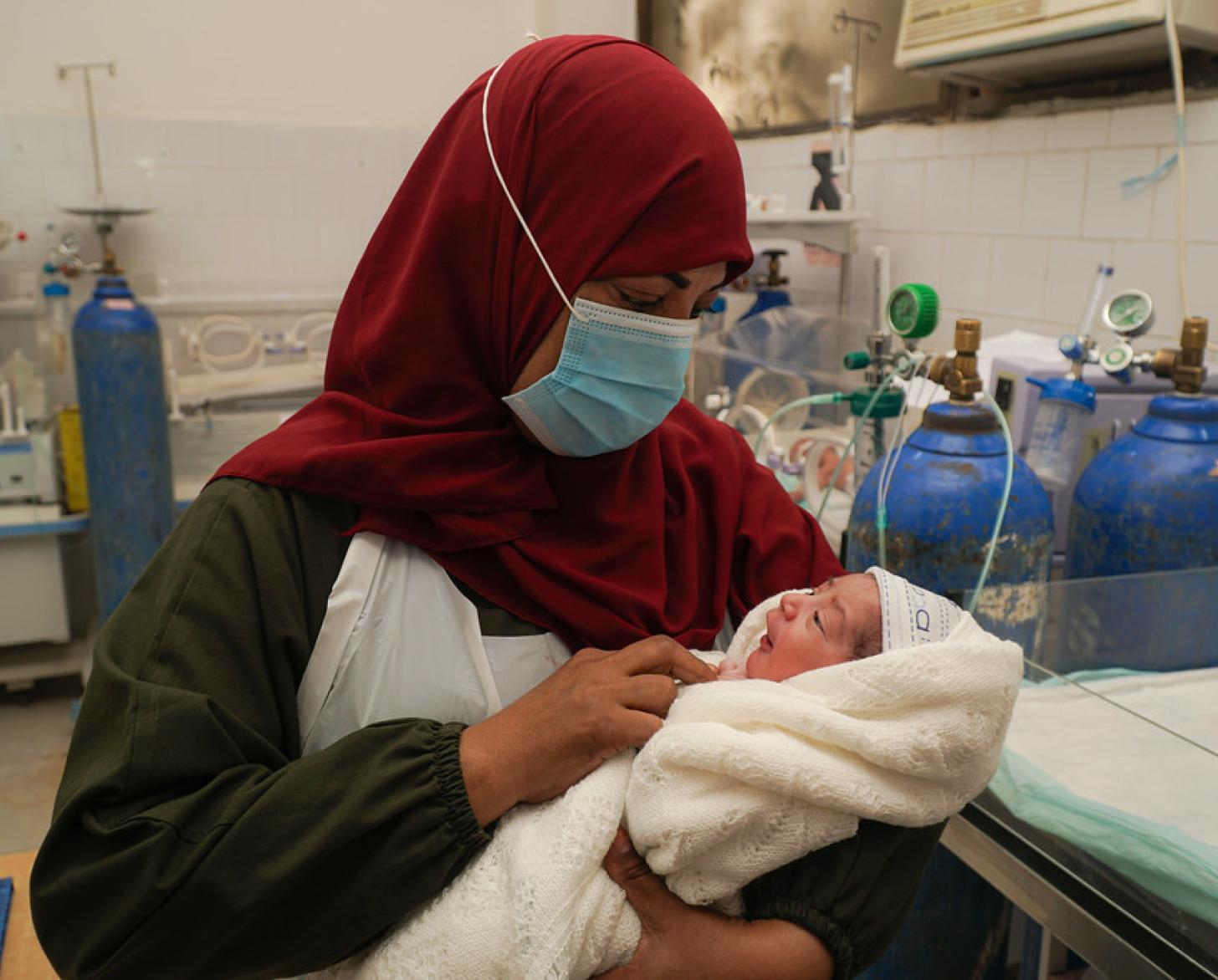 A Yemeni nurse cradles a newborn.
