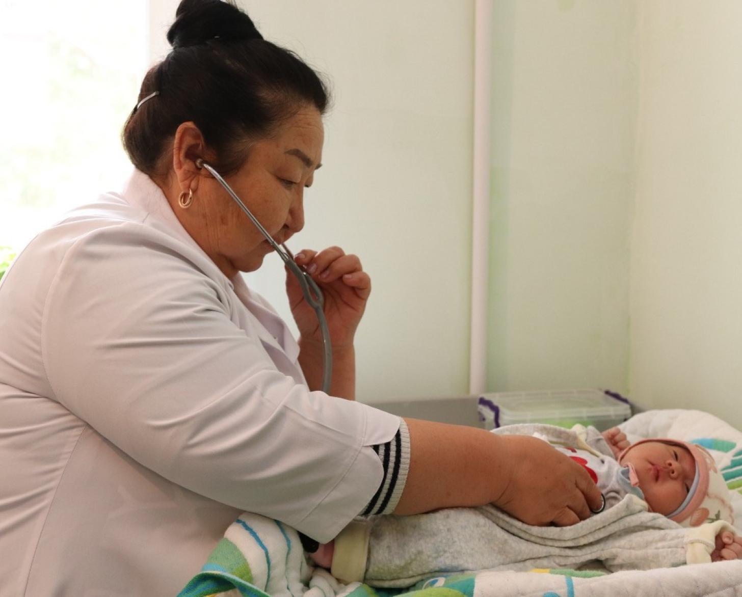 A doctor in Kyrgyzstan examines a baby.