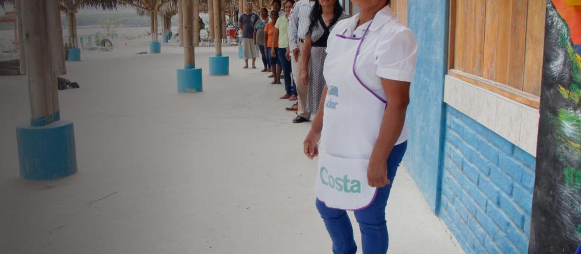 People stand in a line against a wall all facing the camera.
