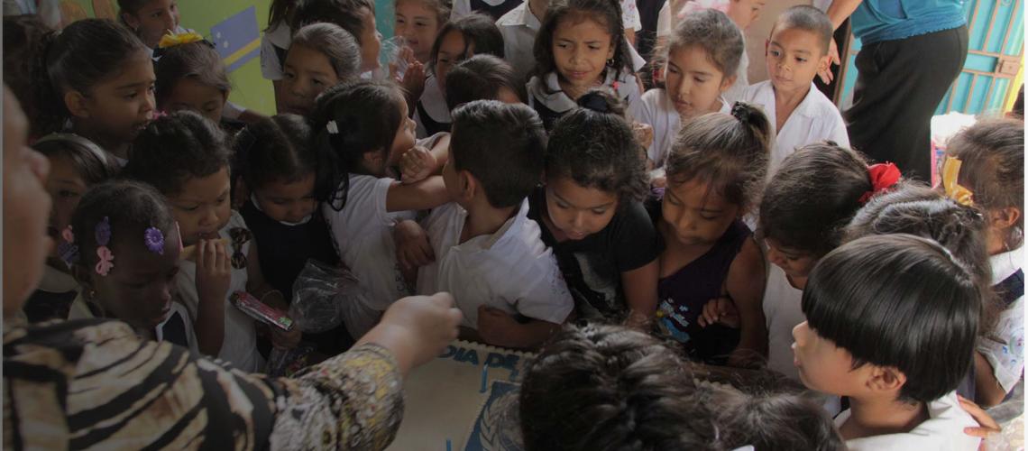 Honduras section banner showing teacher instructing kids