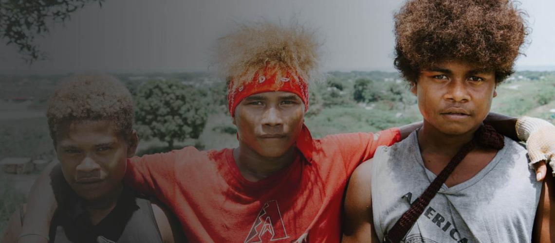 Three young men take a break from chores to pose for a photo.