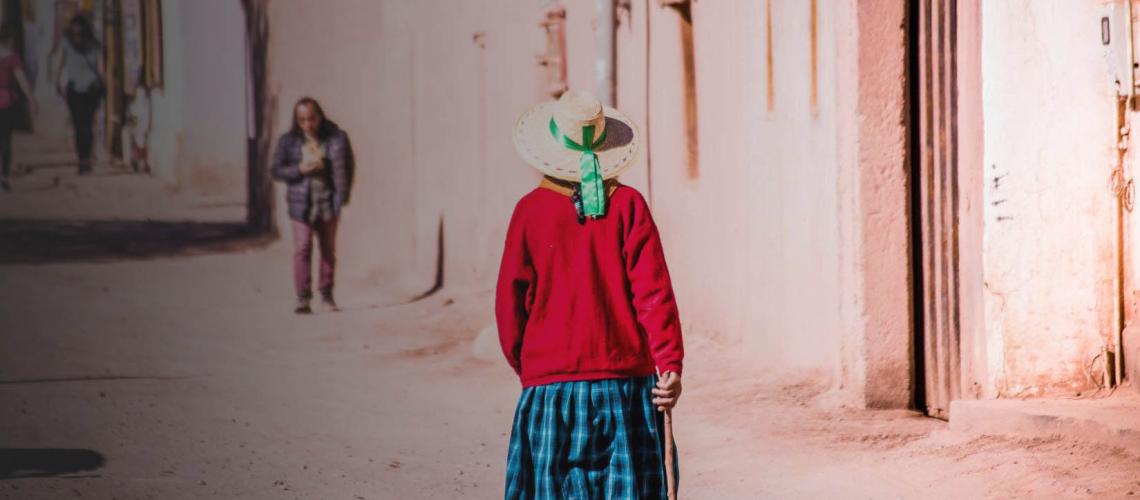 The back of a woman as she walks away from the camera and down a neighbourhood.