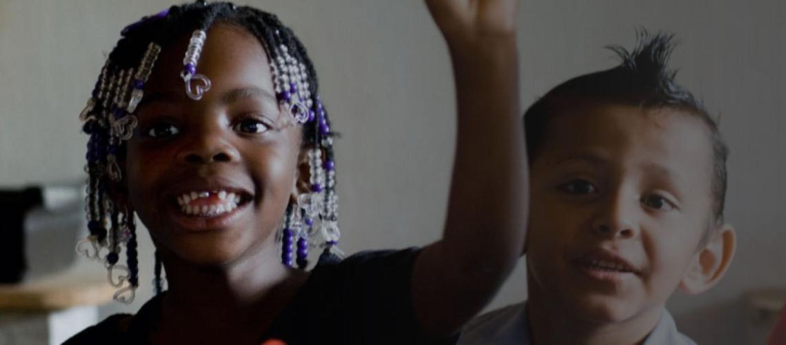 طفل وفتاة صغيران يبتسمان بحماس للكاميرا.