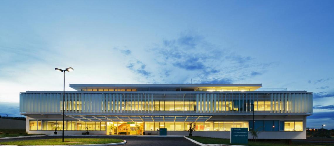 An image of a building at dusk with it's lights on. 