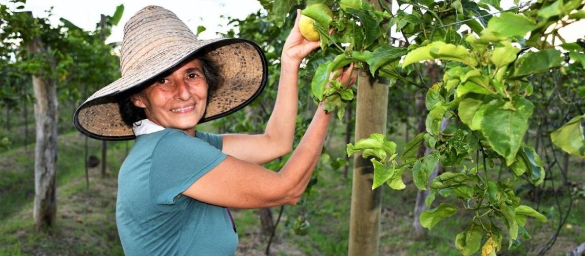 Mujer trabajando en el terreno con un sombrero.