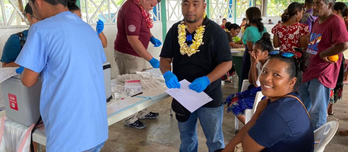 A woman looks at the camera after appearing to receive an inection/shot from a health organization at a clinic.